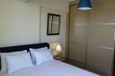 a bedroom with a bed with white pillows and a lamp at Fly me to the moon! in Athens