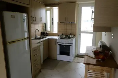 a kitchen with a white refrigerator and a sink at Fly me to the moon! in Athens