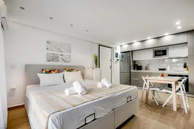 a bedroom with a large bed and a kitchen at Halo - Luxury Studio in Athens in Athens