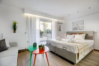 a white bedroom with a bed and a couch at Halo - Luxury Studio in Athens in Athens