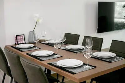 a wooden table with chairs and plates and wine glasses at Mellow 2-Bedroom Apartment in Athens in Athens
