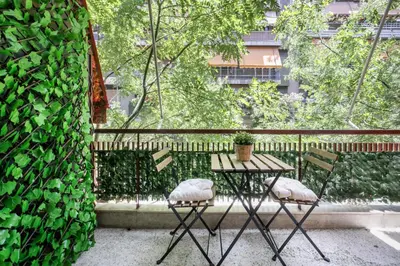 a table and chairs on a balcony with a green wall at Mellow 2-Bedroom Apartment in Athens in Athens