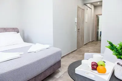 a bedroom with a bed and a table with fruit on it at Elegant Rooms Athens in Athens
