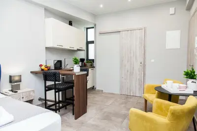 a kitchen and living room with a table and chairs at Elegant Rooms Athens in Athens