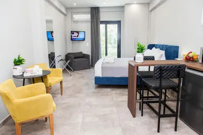 a room with a bed and a table and chairs at Elegant Rooms Athens in Athens