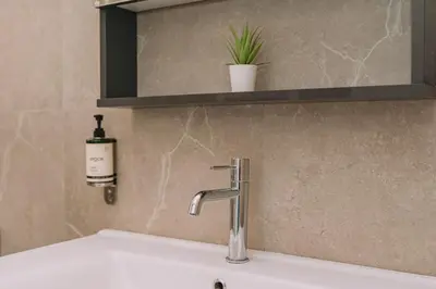 a sink with a faucet and a bottle of soap at ACM Acropolis Apartments in Athens