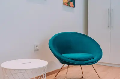 a green chair sitting next to a white table at ACM Acropolis Apartments in Athens