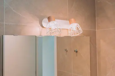 a bathroom with two lights on top of a mirror at ACM Acropolis Apartments in Athens