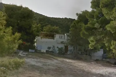 a white house with a hill in the background at Athena's Garden House in Porto Rafti