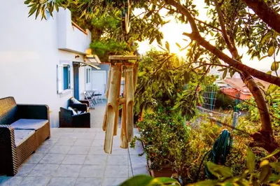 a patio withanas hanging from a tree at Athena's Garden House in Porto Rafti