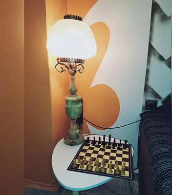 a lamp sitting on a table next to a chessboard at Horizon view apartment port of Piraeus in Piraeus