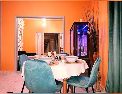 a dining room with a table and blue chairs at Horizon view apartment port of Piraeus in Piraeus