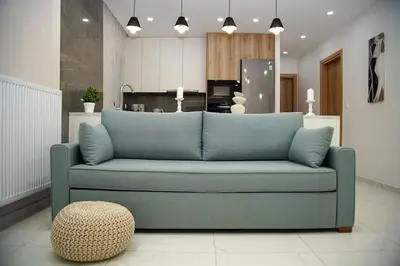 a living room with a blue couch and a kitchen at Urban Elegance Retreat VIPGreece in Athens