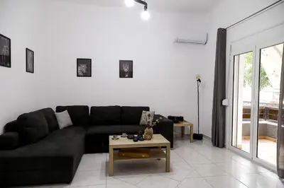 a living room with a black couch and a table at The Grey House in Piraeus
