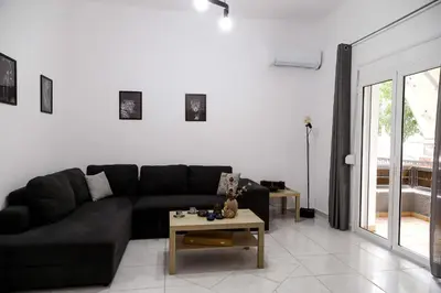 a living room with a black couch and a table at The Grey House in Piraeus
