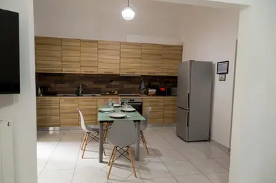 a kitchen with a table with chairs and a refrigerator at The Grey House in Piraeus