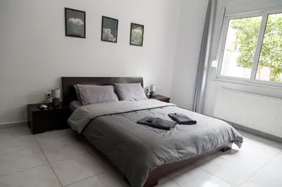 a bedroom with a bed with two towels on it at The Grey House in Piraeus