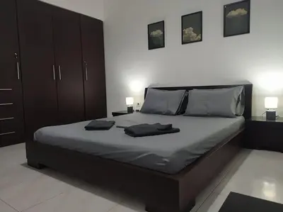 a bedroom with a large bed with two pillows on it at The Grey House in Piraeus