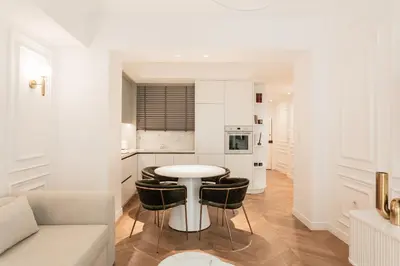 a white kitchen with a table and some chairs at Elegant apartment a breath away from the Acropolis in Athens