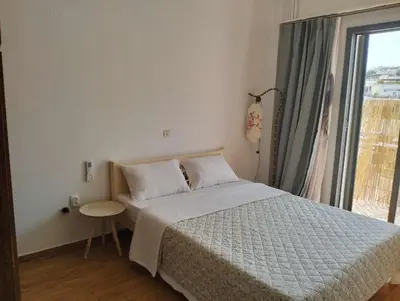 a bedroom with a bed and a large window at rpieras in Piraeus