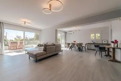 a living room with a couch and a table at Villa Poseidon Athens Riviera in Lagonissi
