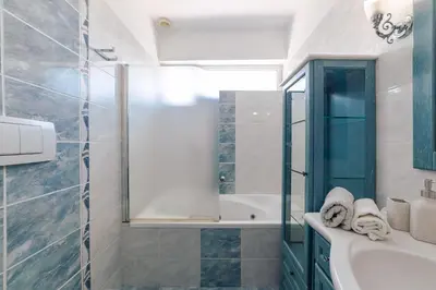 a bathroom with a tub and a sink and a shower at Villa Poseidon Athens Riviera in Lagonissi