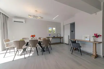 a dining room and kitchen with a table and chairs at Villa Poseidon Athens Riviera in Lagonissi