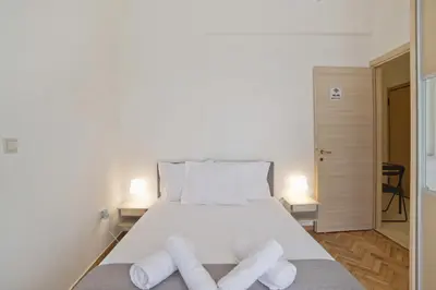 a bedroom with a white bed with two rolled towels at Cozy Pagrati Nest Near Athens Center, AC, Wifi in Athens