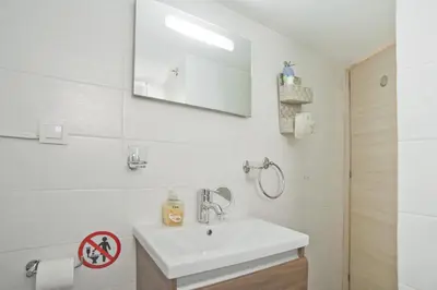 a white bathroom with a sink and a mirror at Cozy Pagrati Nest Near Athens Center, AC, Wifi in Athens