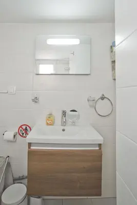 a bathroom with a sink and a toilet and a mirror at Cozy Pagrati Nest Near Athens Center, AC, Wifi in Athens