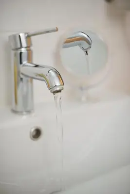 a bathroom sink with water running from a faucet at Cozy Pagrati Nest Near Athens Center, AC, Wifi in Athens