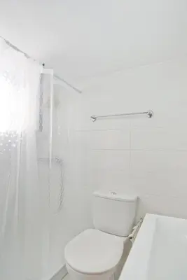 a white bathroom with a toilet and a shower at Cozy Pagrati Nest Near Athens Center, AC, Wifi in Athens