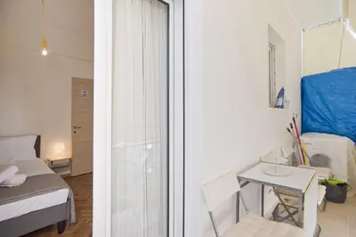 a small room with a bed and a table and a window at Cozy Pagrati Nest Near Athens Center, AC, Wifi in Athens