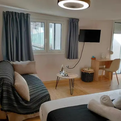a living room with a couch and a table and a television at Gargaretta Suites Wildflower 4 Acropolis Museum District in Athens
