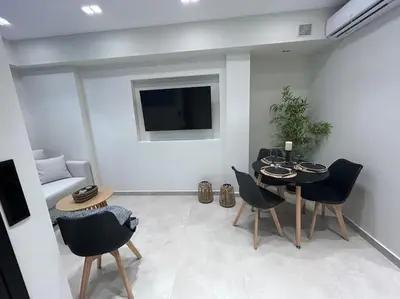 a living room with a table and chairs and a television at BlueMotion - Ferry 65 in Piraeus