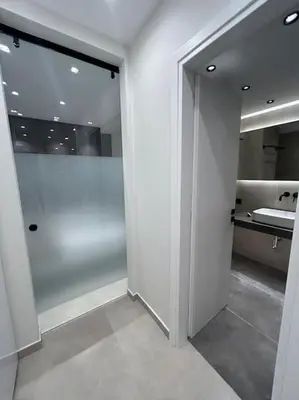 a white bathroom with a sink and a shower at BlueMotion - Ferry 65 in Piraeus