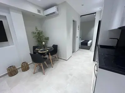 a living room with a table and chairs and a bedroom at BlueMotion - Ferry 65 #2 in Piraeus