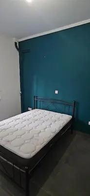 a bed in a room with a blue wall at spiti in Athens