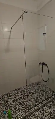 a shower in a bathroom with a black and white floor at spiti in Athens