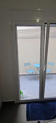 a room with a sliding glass door with a table and chairs at spiti in Athens