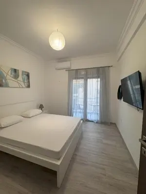 a bedroom with a white bed and a window at Ntinos Apartment Center Exarcheia in Athens
