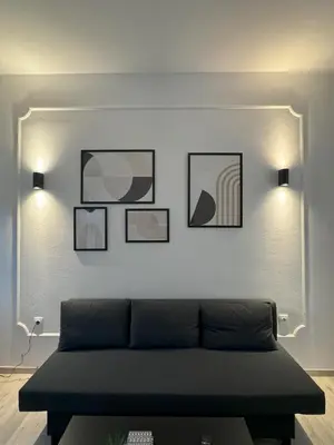 a living room with a couch and pictures on the wall at Ntinos Apartment Center Exarcheia in Athens