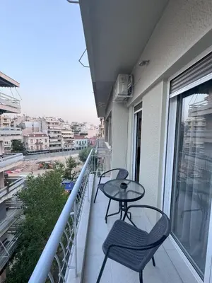 a balcony with two chairs and a table on a balcony at Ntinos Apartment Center Exarcheia in Athens