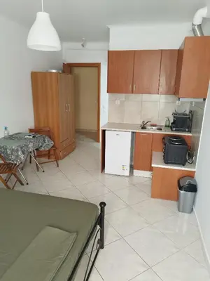 a kitchen with wooden cabinets and a table and a table at Small apartment in the heart of Piraeus! Notara 43 in Piraeus