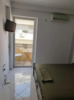 a room with a bed and a view of a patio at Small apartment in the heart of Piraeus! Notara 43 in Piraeus