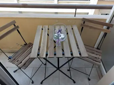 a wooden picnic table with a vase of flowers on it at Small apartment in the heart of Piraeus! Notara 43 in Piraeus