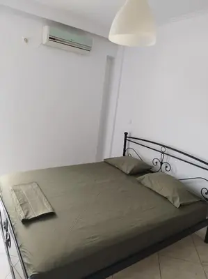 a bed in a white room with a window at Small apartment in the heart of Piraeus! Notara 43 in Piraeus