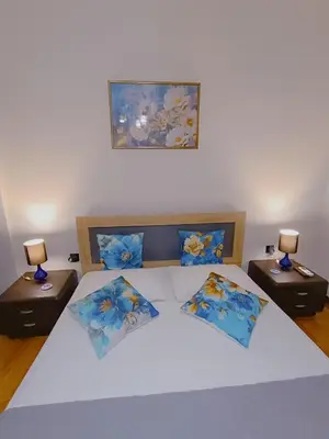 a bedroom with a large bed with two nightstands and two lamps at Peacock in Athens