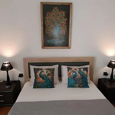 a bedroom with a bed with a picture on the wall at Peacock in Athens