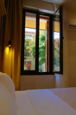 a bedroom with a bed and two windows at Absolute Athens Acropolis Muses in Athens